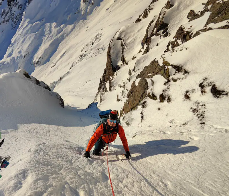 Klatrer i solbelyst snørenne mellom klippevegger