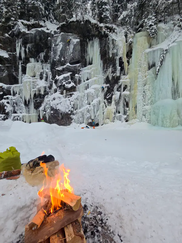 Bål ved isfossen i vinterlys